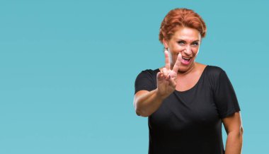 Mutlu yüz zafer işareti yaparken kameraya göz kırpıyor ile gülümseyen izole arka plan Atrractive üst düzey beyaz Kızıl saçlı kadın. İki numaralı.