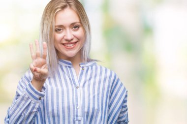 Sarışın genç kadın gösterilen ve parmakları ile işaret izole arka plan üzerinde üçüncü ise kendinden emin ve mutlu gülümseyerek.