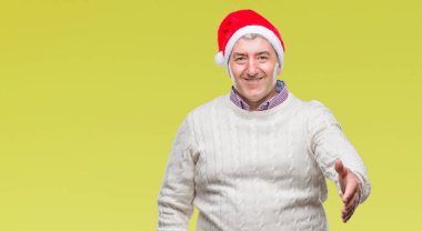 Üst düzey yakışıklı Noel şapka üzerinde arka plan dostu sunan karşılıklı tebrik ve davet edici gülümseyen izole. Başarılı iş.