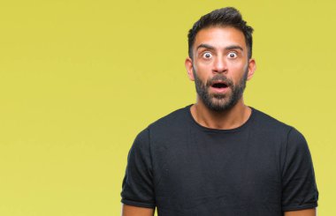 Yetişkin İspanyol adam korkuyor ve şok sürpriz ifade ile izole arka plan üzerinde korku ve yüz heyecanlı.