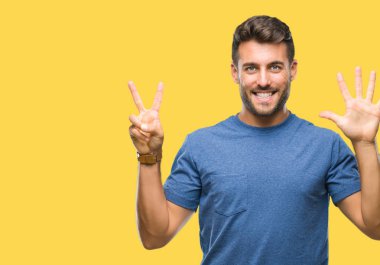 Yakışıklı delikanlı gösterilen ve parmakları ile işaret izole arka plan üzerinde kendinden emin ve mutlu gülümseyerek süre yedi numara.