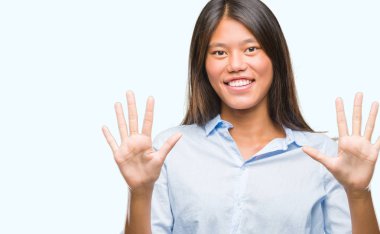 Genç Asyalı iş kadını gösterilen ve parmakları ile işaret izole arka plan üzerinde kendinden emin ve mutlu gülümseyerek süre on numara.