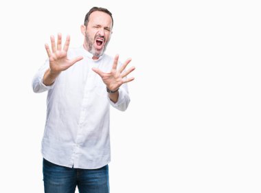 Şokta bağırarak orta yaş ağarmış üst düzey adam izole arka plan korkuyor ve korku ifade dur hareketi el ile ile çok korkmuş. Panik kavramı.