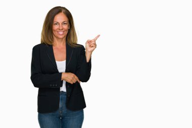 Kameraya bakarak yan el ve parmak ile işaret eden güzel orta yaş iş yetişkin kadın yüzünde kocaman bir gülümseme ile izole arka plan.