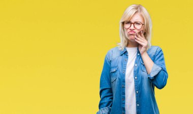 Diş ağrısı veya dişlerde dişlerle ilgili hastalık nedeniyle ağız acı ifadesi ile el ile dokunmak izole arka plan üzerinde gözlük takan genç güzel sarışın kadın. Diş hekimi kavramı.