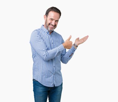 Yakışıklı orta yaş zarif komuta sizde izole arka plan gösteren palm el ve yukarıya, mutlu ve neşeli gülümseyen baş parmakları Tamam jest yapıyor