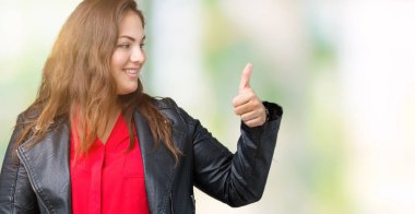 Artı boyutu genç kadın moda deri ceket giyiyor gurur seyir izole arka plan üzerinde güzel, işin gülümseyen jest tarafa thumbs up
