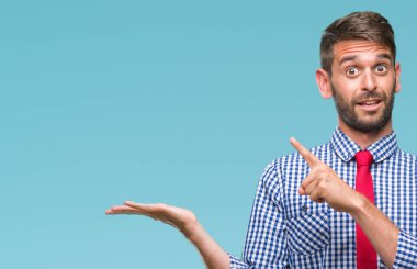 Genç yakışıklı iş adamı üzerinden hayran ve el ile sunulması ve parmak ile işaret ederken kameraya gülümseyen izole arka plan.