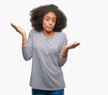 Genç afro Amerikan kadın izole arka plan clueless ve şaşkın bir ifadeyle kollar ve eller kaldırdı. Şüphe kavramı.