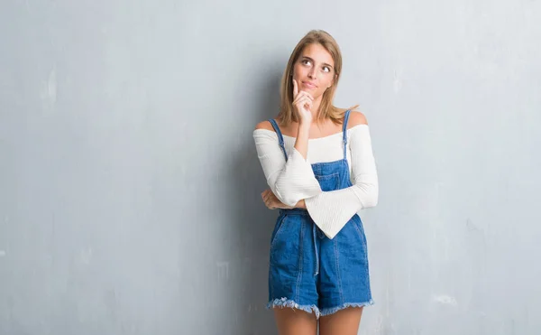 Hermosa Mujer Joven Pie Sobre Pared Gris Grunge Con Mano — Foto de Stock