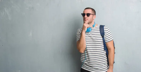 Young Caucasian Student Man Grey Grunge Wall Wearing Headphones Backpack — Stock Photo, Image