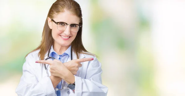 成熟した医師中年女性の身に着けている医療コート分離上背景ポインティング指 別の方向で両側に反対 — ストック写真