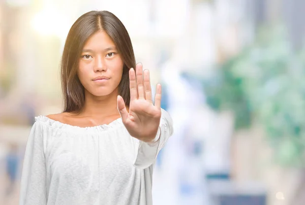 年轻的亚洲妇女在孤立的背景下做停止唱歌与手掌的手 脸上带有否定和严肃手势的警告表达式 — 图库照片