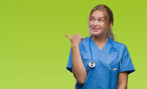 探していると親指側に上向きの幸せそうな顔を浮かべて孤立の背景の上の外科医の制服を着て若い白人医師女性 — ストック写真