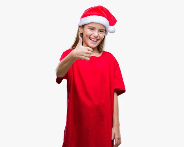 年轻美丽的女孩戴着圣诞节帽子在孤立的背景做愉快的拇指手势与手 批准表达式看着相机显示成功 — 图库照片