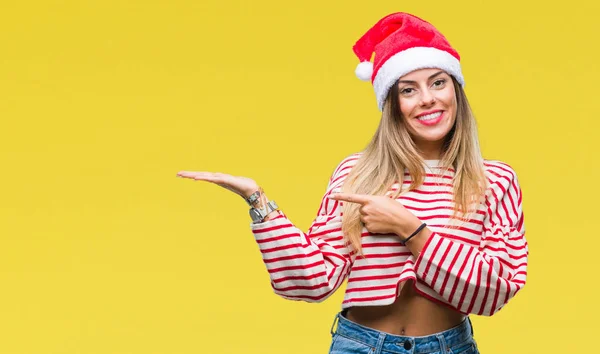 驚くし 手とを提示 指で指している間カメラに笑顔孤立の背景にクリスマスの帽子をかぶって若い美しい女性 — ストック写真