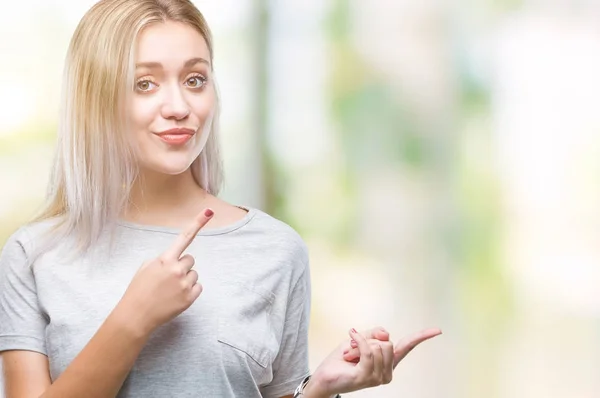 Joven Rubia Sobre Fondo Aislado Sonriendo Mirando Cámara Apuntando Con —  Fotos de Stock