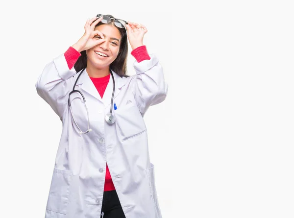 年轻的阿拉伯医生妇女在孤立的背景下做 手势用手微笑 眼睛看通过手指与愉快的面孔 — 图库照片
