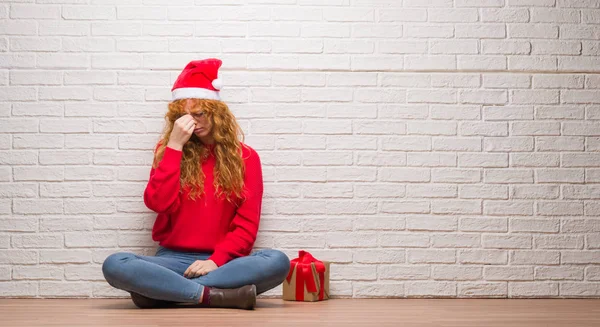 Junge Rothaarige Frau Sitzt Über Backsteinmauer Mit Weihnachtsmütze Müde Reiben — Stockfoto