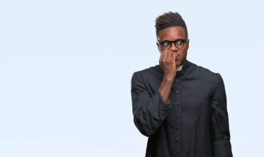 Genç Afro-Amerikan rahip adam stresli ve gergin elle çivi ısırma ağzına bakarak izole arka plan üzerinde. Anksiyete sorunu.