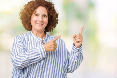 Gülümseyen ve iki elleri ve parmakları ile tarafına işaret kamera bakarak izole arka plan üzerinde Donanma forması giyen güzel orta ager üst düzey kadın.