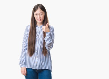 Genç Çinli iş kadını ile büyük mutlu gözlüklü izole arka plan üzerinde ok işareti yapıyor gülümse, parmaklarıyla, mükemmel işaret parmak