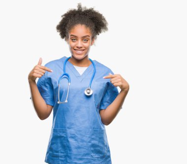 Yüzünde gülümseme ile kendinden emin görünüyorsun, kendini gururlu ve mutlu parmakları ile işaret izole arka plan genç afro Amerikalı doktor kadın.