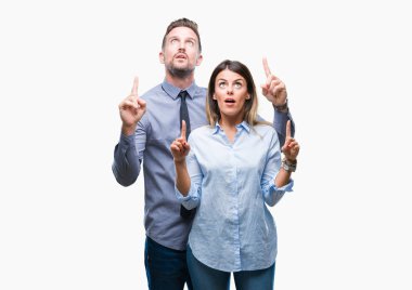 Genç işçiler iş çift izole arka plan üzerinde hayret ve yukarıya bakıp parmakları ile işaret şaşırttı ve silah kaldırdı.