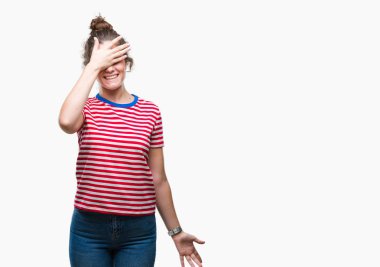 Güzel esmer kıvırcık saçlı Genç kız gülümsüyor ve gözleri için sürpriz kapsayan yüz el ile gülüyor izole arka plan üzerinde rahat bakmak giyiyor. Kör kavramı.