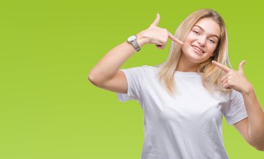 Kendinden emin gösterilen ve işaret parmakları diş ve ağız ile gülümseyen izole arka plan üzerinde beyaz kadın. Sağlık kavramı.