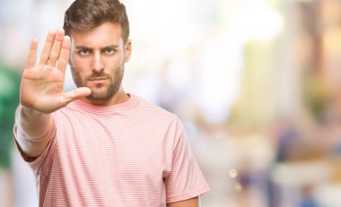 Yakışıklı delikanlı dur yapıyor izole arka plan üzerinde şarkı elin avuç ile. Negatif ve ciddi bir jest yüz ifadesiyle uyarı.