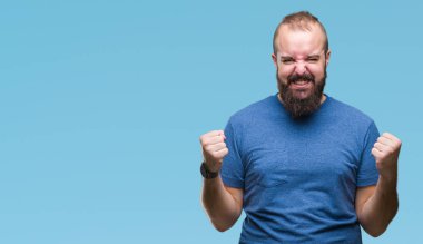 İzole arka plan kutlama üzerinde genç beyaz hipster adam şaşırttı ve başarı için kaldırdı kollarını açarak hayret ve gözleri açık. Kazanan kavramı.