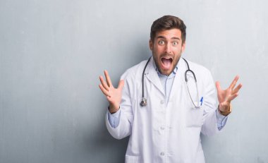 Yakışıklı genç doktor adam gri grunge kutluyor deli duvar ve başarı için kaldırdı kollarını açarak hayrete ve heyecanlı çığlık gözleri açık. Kazanan kavramı
