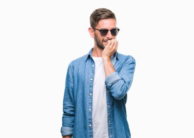 Genç yakışıklı adam stresli ve gergin ile izole arka plan üzerinde güneş gözlüğü takıyor tırnak ısırma dudaklarından eller. Anksiyete sorunu.