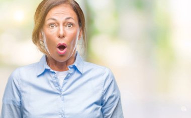 Orta yaş üst düzey İspanyol kadın izole arka plan korkuyor ve sürpriz ifade ile şok yüzünden korku ve yüz heyecanlı.