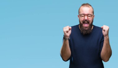 Genç beyaz hipster adam kızgın ve silah ile başarı için deli izole arka plan kutluyor üzerinde güneş gözlüğü takıyor kaldırdı ve heyecanlı çığlık gözler kapalı. Kazanan kavramı