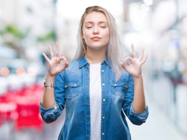 Sarışın genç kadın izole arka plan üzerinde dinlenmek ve gülümseyen gözlerle parmak ile meditasyon jest yapıyor kapalı. Yoga kavramı.