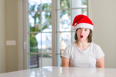 Down sendromu kadın evde giyen Noel şapka korkuyor şok sürpriz yüz, korkuyor ve heyecanlı korku ifadesi ile