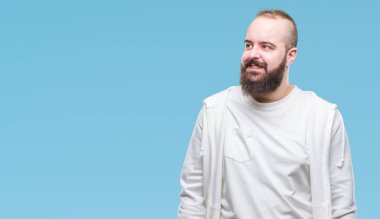 Spor kıyafetlerle üzerinde genç beyaz hipster adam arka plan uzak tarafına gülümseme ile yüzünde, doğal ifade arıyorum izole. Kendine güvenen gülüyor.