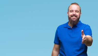 Üzerinde mavi gömlek giymiş genç beyaz hipster adam arka plan dostu sunan karşılıklı tebrik ve davet edici gülümseyen izole. Başarılı iş.