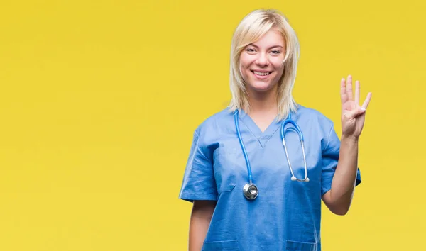 Young beautiful blonde doctor woman wearing medical uniform over isolated background showing and pointing up with fingers number four while smiling confident and happy.