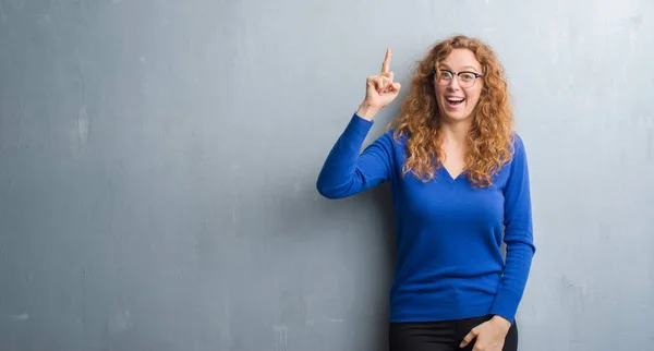 Young Redhead Woman Grey Grunge Wall Pointing Finger Successful Idea — Stock Photo, Image