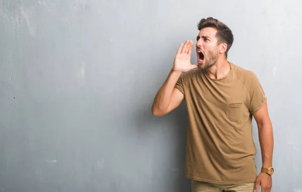 Gutaussehender Junger Mann Über Grauer Grunge Wand Der Laut Schreit — Stockfoto