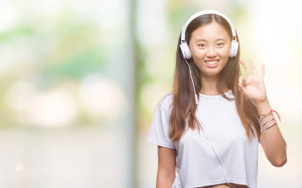 Junge Asiatische Frau Musik Hören Kopfhörer Isoliert Hintergrund Tun Zeichen — Stockfoto