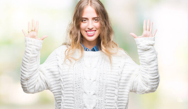 Beautiful young blonde woman wearing winter sweater over isolated background showing and pointing up with fingers number ten while smiling confident and happy.