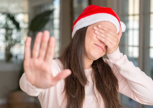 Krásná Mladá Žena Nosí Santa Claus Klobouk Doma Oči Rukama — Stock fotografie