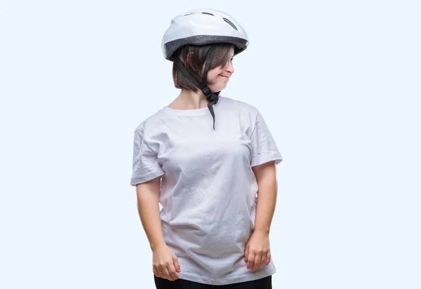 年轻的成人骑自行车妇女与唐氏综合征佩戴安全头盔在孤立的背景看一边与微笑的脸上 自然的表达 笑的自信 — 图库照片