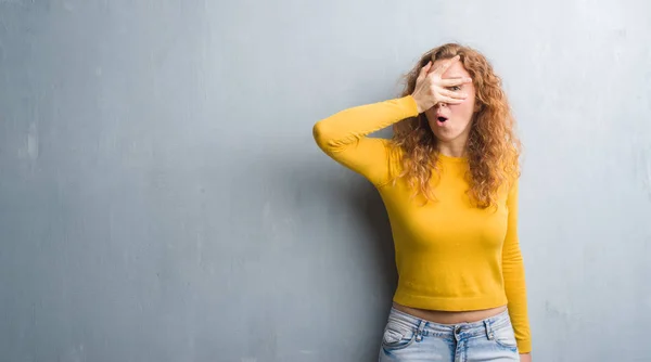 Joven Pelirroja Sobre Una Pared Grunge Gris Asomándose Impactante Cara —  Fotos de Stock