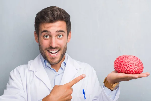 Bonito Jovem Médico Psicólogo Homem Sobre Parede Grunge Cinza Segurando — Fotografia de Stock