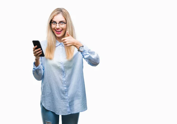 年轻美丽的金发碧眼的女商人使用智能手机在孤立的背景高兴与灿烂的笑容做确定的标志 用手指竖起大拇指 优秀的标志 — 图库照片